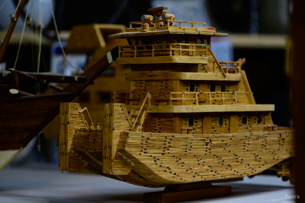 Close-up of a detailed wooden ship model showing layered hull construction and upper decks
