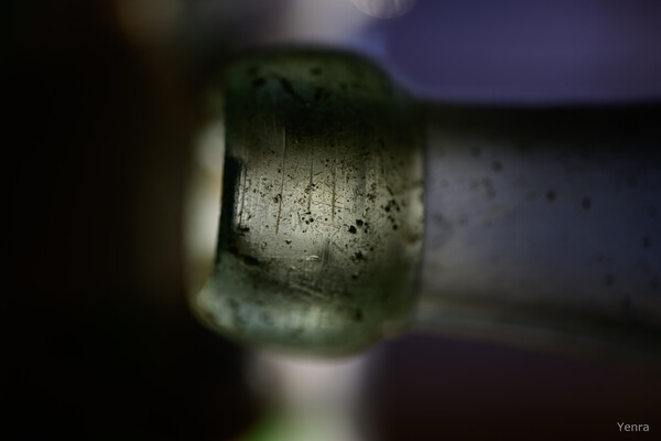 Close-up of a scratched bottle neck with dark background