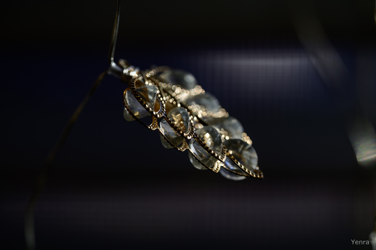 Close up of a hanging glass ornament with metal filigree against a dark background