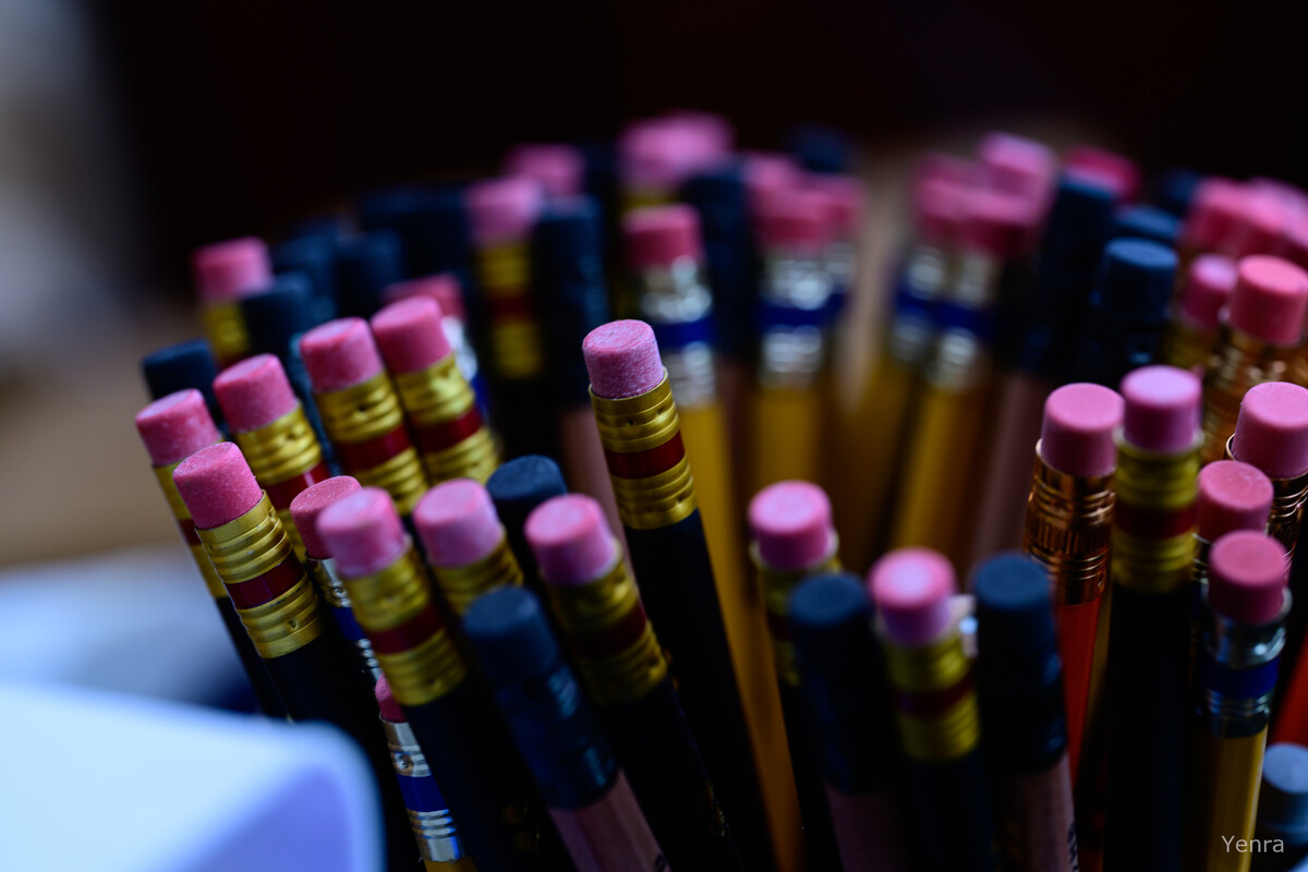 Close-up of many pencils with pink erasers arranged in a container