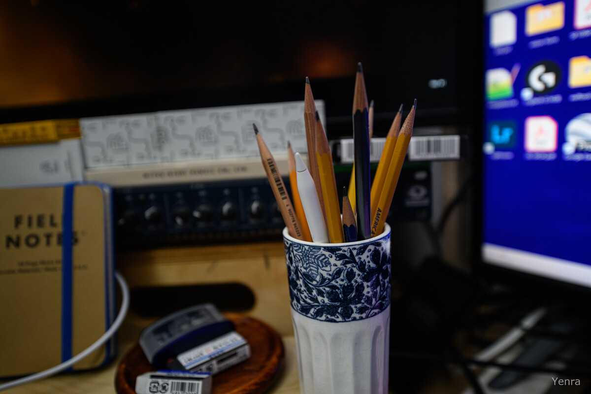 Ceramic pencil holder and Field Notes notebook on a desk