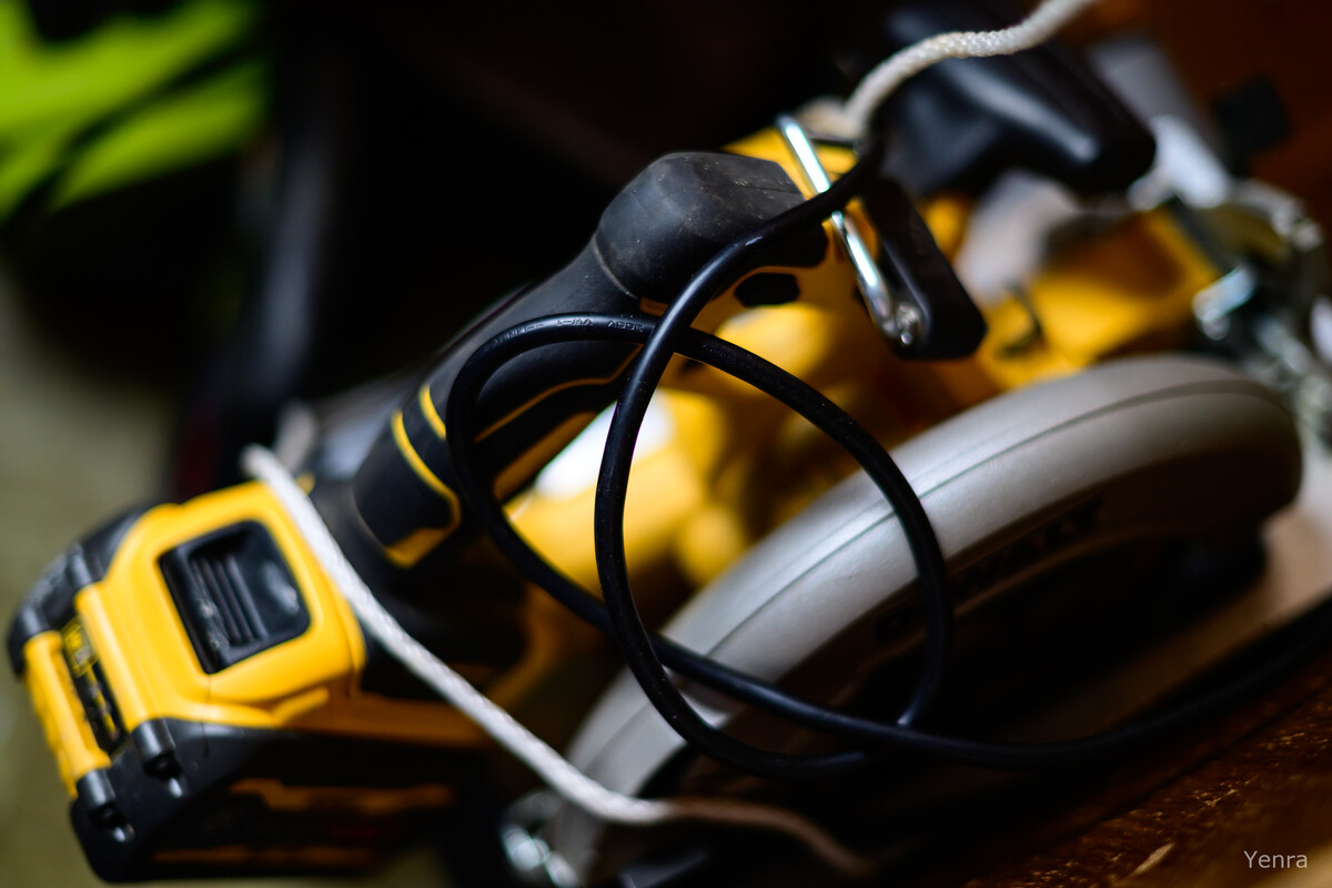 Close-up of a yellow and black Dewalt circular saw with a black cord wrapped around its handle.