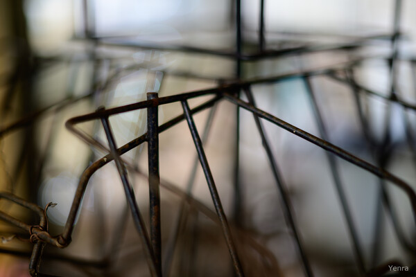 Close-up of a rusty wire book rack with a blurred background