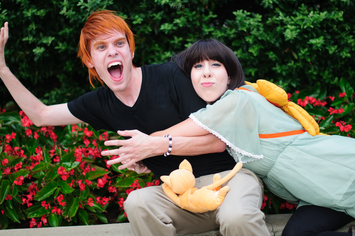 Two people dressed in cosplay outfits posing together with plushie dolls.