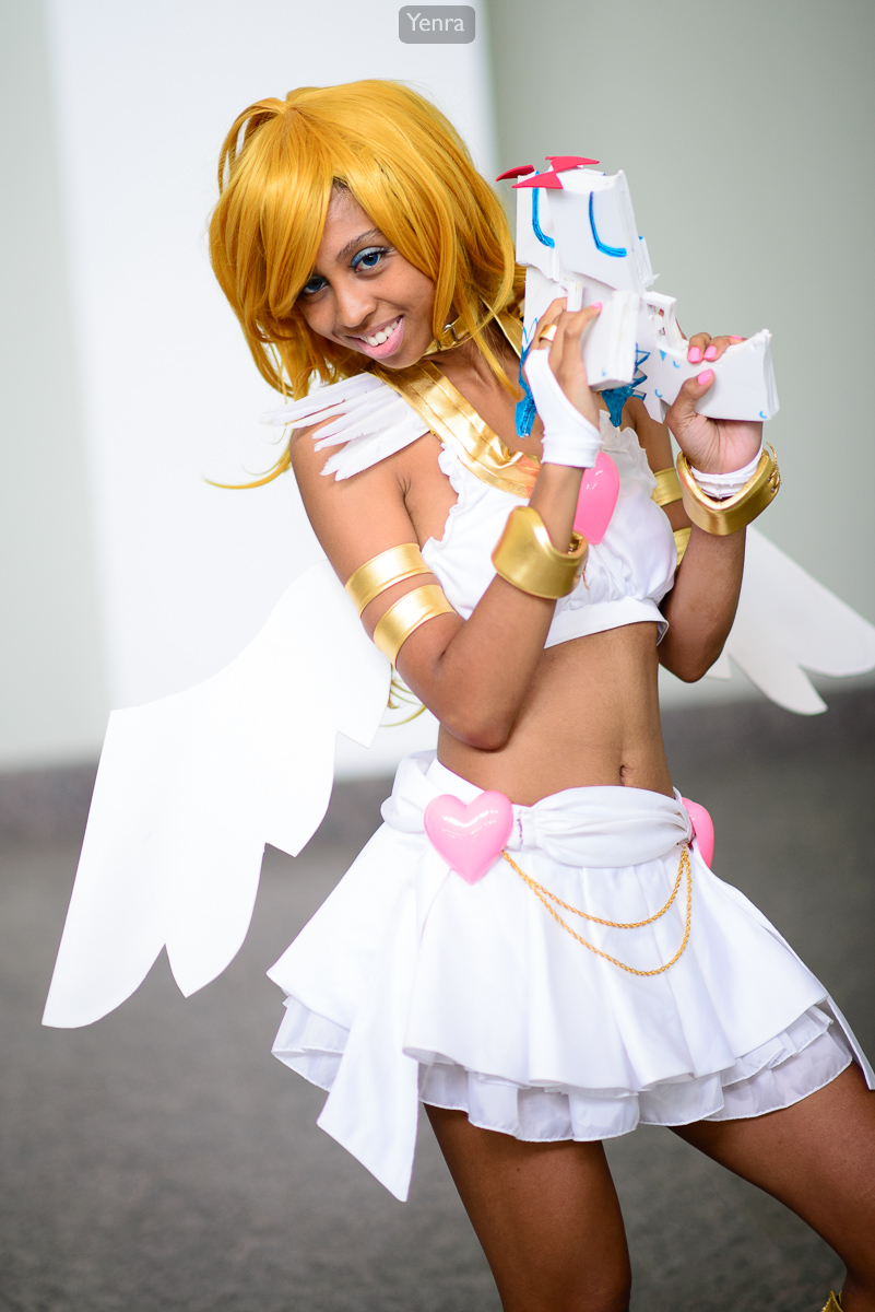 A girl dressed as Angel Panty from Magical Girl Lyrical Nanoha holds a toy gun.