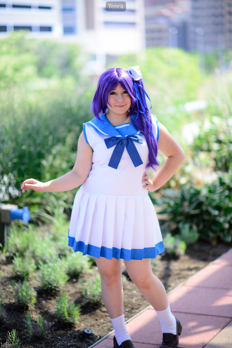 A young woman in a sailor-style outfit poses for a photograph in an outdoor setting.